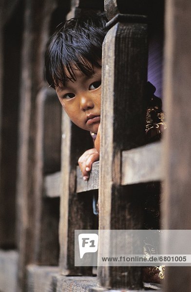 Young Child Looking Out From Behind Bars  Thimphu  Bhutan