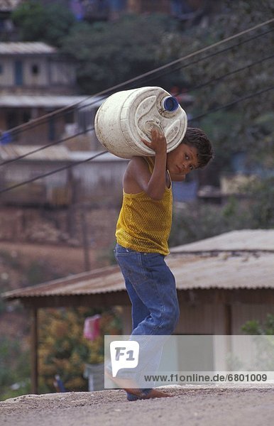 Boy Carrying Container On Shoulders