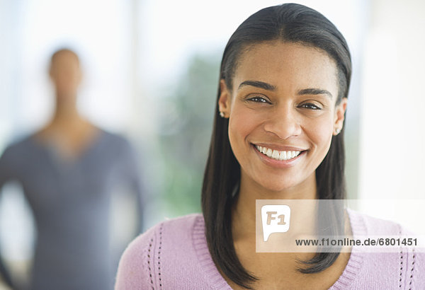 Portrait of woman smiling  man in background