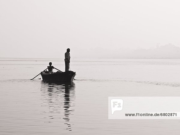 Two People In A Canoe On The River At Sunset  Ganges River Varanasi India