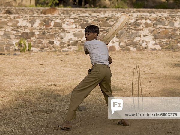 Boy Playing Cricket Using Makeshift Equipment  Aravalli Hills Rajasthan India
