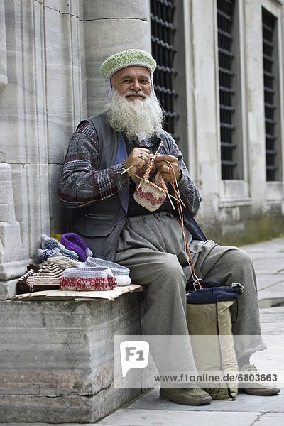 Man Knitting Outdoors In Asia