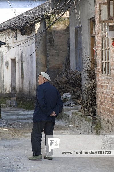Man Standing On Sidewalk In China