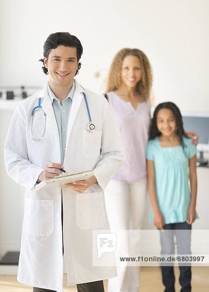 Doctor with patients (woman and girl aged 12-13) in office