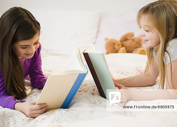 Two girls reading in bed