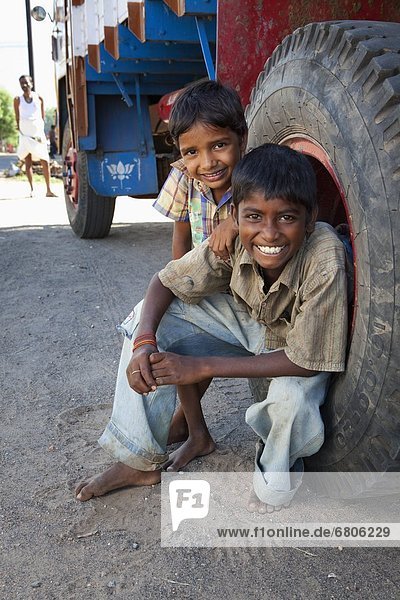 sitzend  nebeneinander  neben  Seite an Seite  Junge - Person  Lastkraftwagen  2  groß  großes  großer  große  großen  Indien  Tamil Nadu
