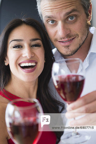 Paar stößt an mit Rotwein