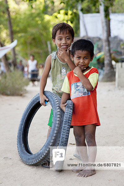 Two Young Boys With Their Toy Tires In A Village  El Nido Bacuit Archipelago Palawan Philippines