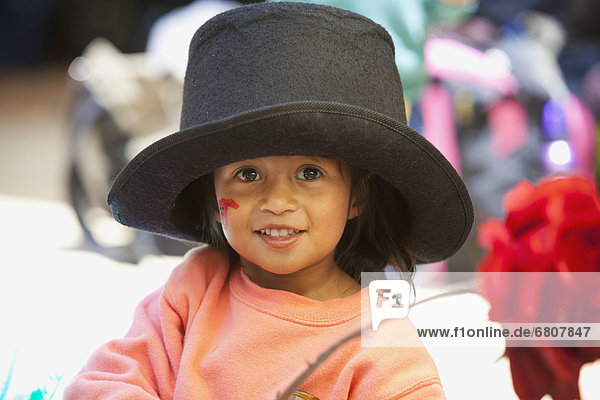 A young girl wearing a large top hat  antigua guatemala