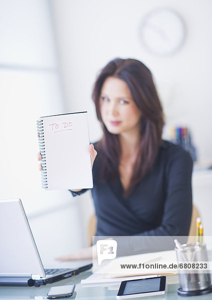 Businesswoman at desk showing to do list