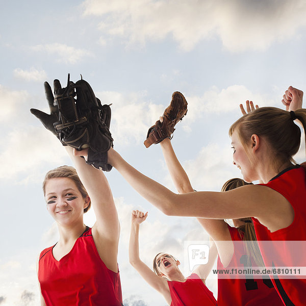 Girls (12-13) celebrating during playing softball