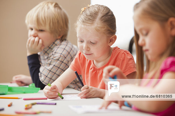 Children (4-5) drawing in kindergarten
