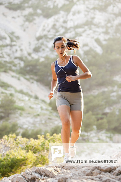France  Marseille  Young woman jogging on rocky terrain