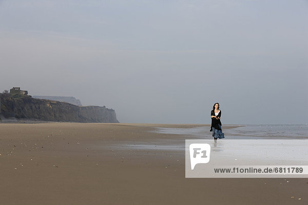 France  Pas-de-Calais  Escalles  Young woman strolling on empty beach