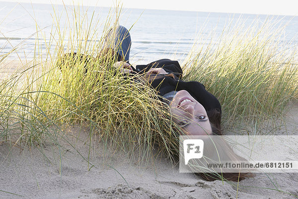 Netherlands  Zeeland  Haamstede  Woman lying on sand dune