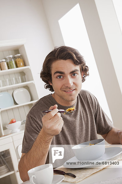 Portrait of young man eating breakfast