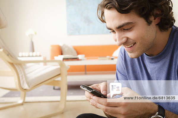 Smiling woman using mobile at home