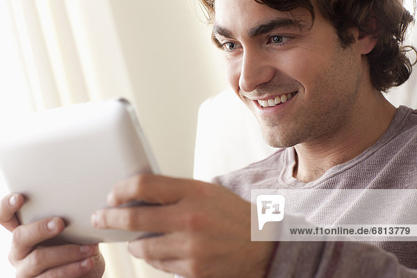 Smiling man using digital tablet