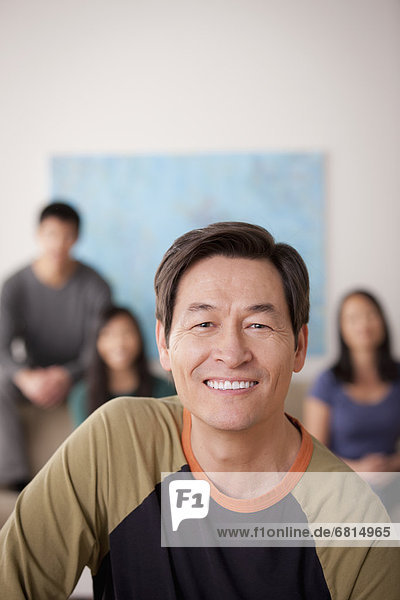 Portrait of mature man with family in background