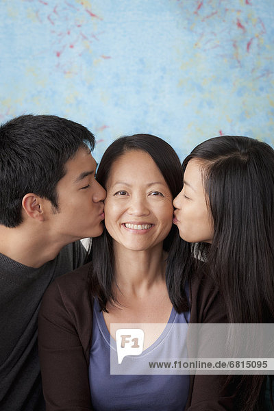 Smiling mother kissed by her children