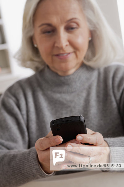 Portrait of smiling senior woman using mobile