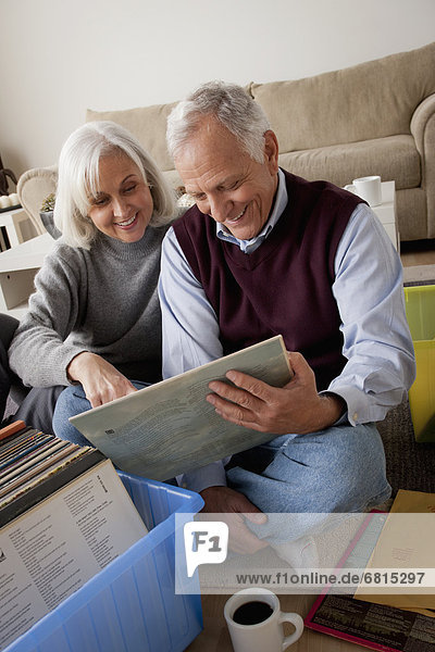 Smiling senior couple looking at vinyl's in living room