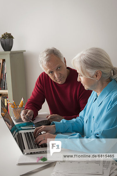 Senior couple working together in home office