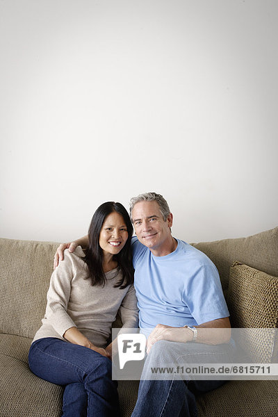 Couple in close embrace sitting on sofa