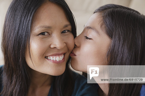 Daughter giving mother kiss on cheek