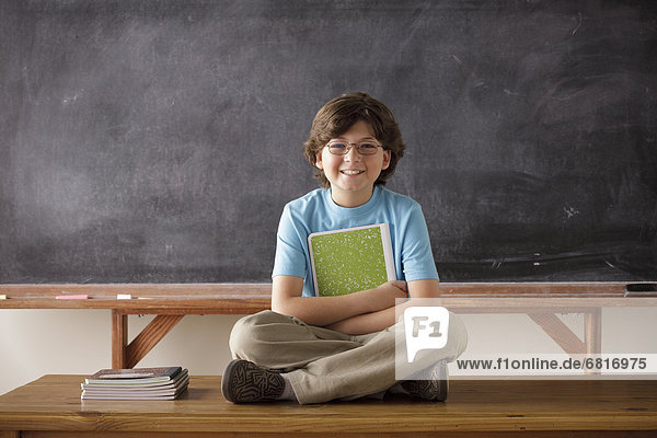 Schneidersitz  sitzend  Portrait  frontal  Grundschüler  10-11 Jahre  10 bis 11 Jahre  Schreibtafel  Tafel