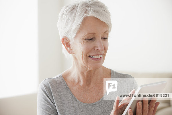 Smiling senior woman using digital tablet