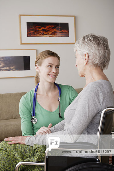 Young female nurse taking care of senior woman
