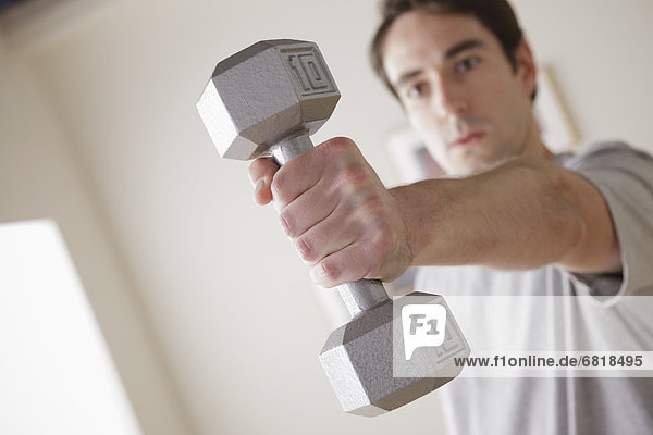 Young man exercising with dumbbell