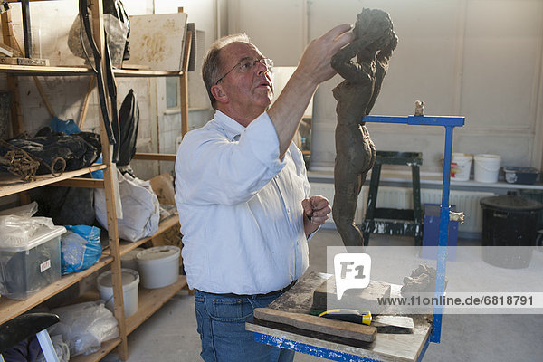 Retired man working on sculpture