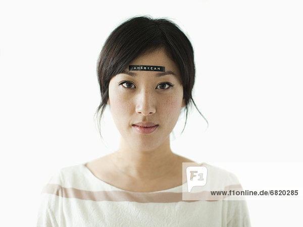 Portrait of young woman with word 'American' on forehead  studio shot