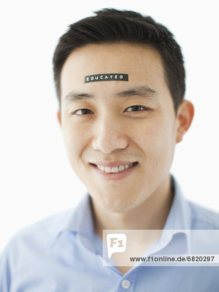 Portrait of young man with word educated on forehead  studio shot