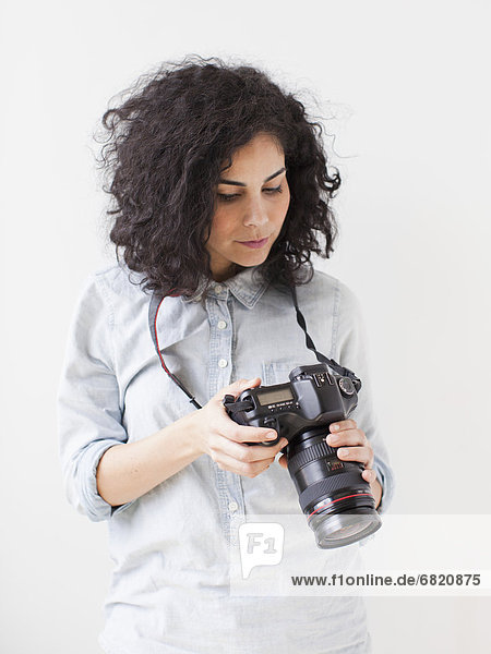 Beautiful young woman holding professional camera