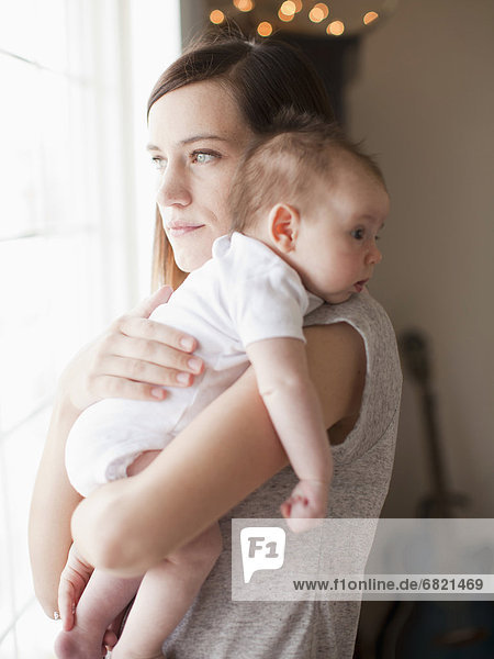Mother embracing baby girl (2-5 months)