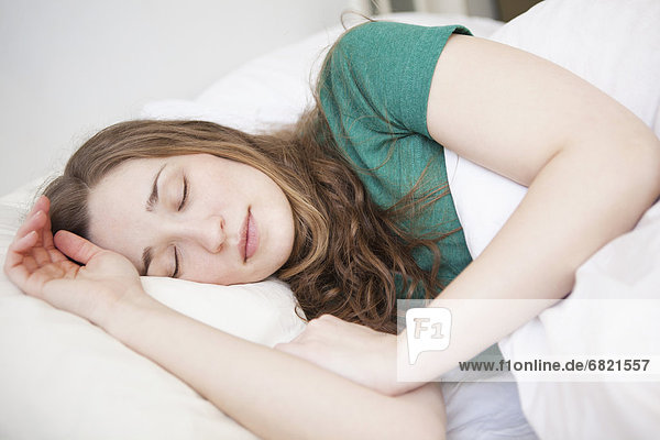 Junge Frau schläft im Bett