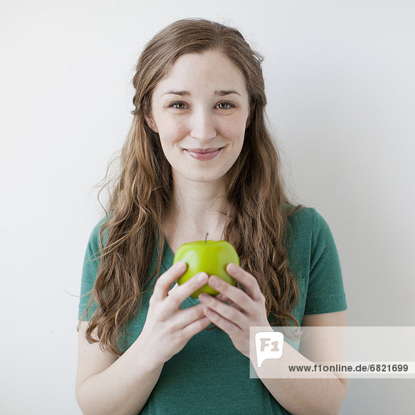 Frau  Fröhlichkeit  grün  halten  jung  Apfel  schießen  Studioaufnahme