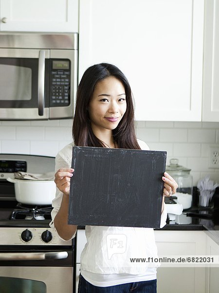 Portrait  Frau  lächeln  Küche  halten  jung  Schreibtafel  Tafel