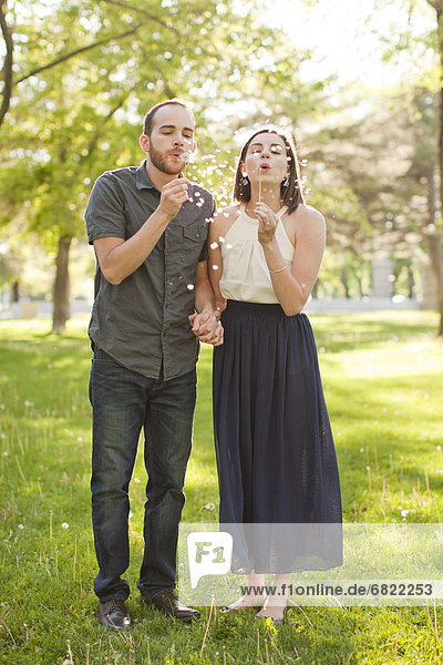 Happy young couple blowing bubbles