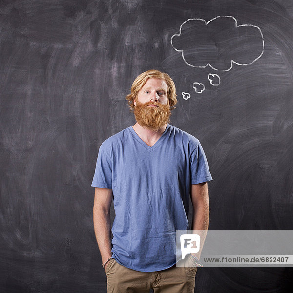 Man in front of blackboard with drawing depicting speech bubble