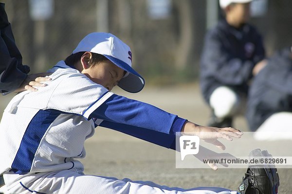 Boys in baseball team stretching in field  differential focus