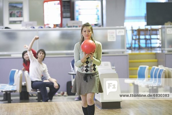 Young woman bowling in bowling alley
