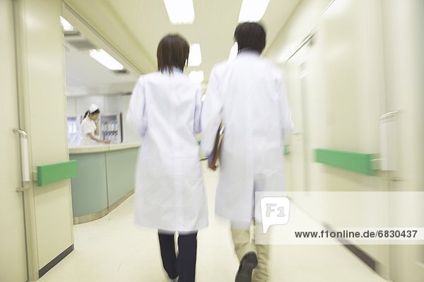 Doctors walking in corridor  blurred motion