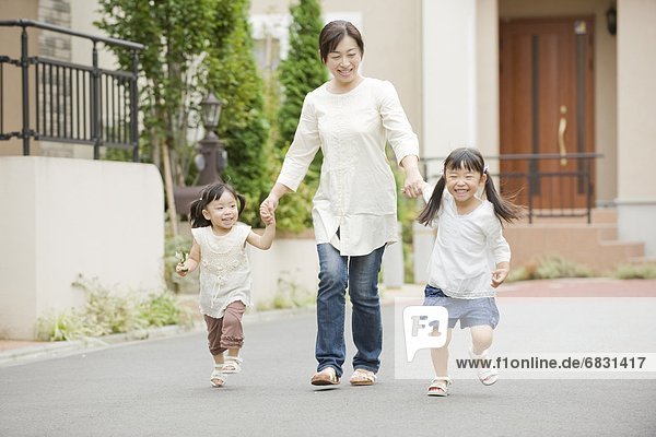 Mother and daughters holding hands and walking
