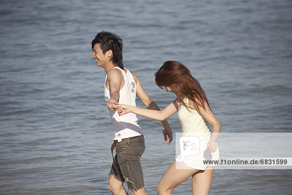Young couple walking on beach  Guam  USA