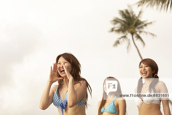 Young women shouting and laughing in bikini  Guam  USA