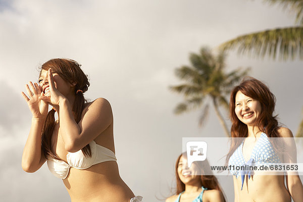 Young women shouting and smiling in bikini  Guam  USA